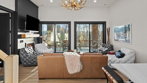 Ein modernes Wohnzimmer mit einer großen Couch, einem Kamin und einer Chandelüster.