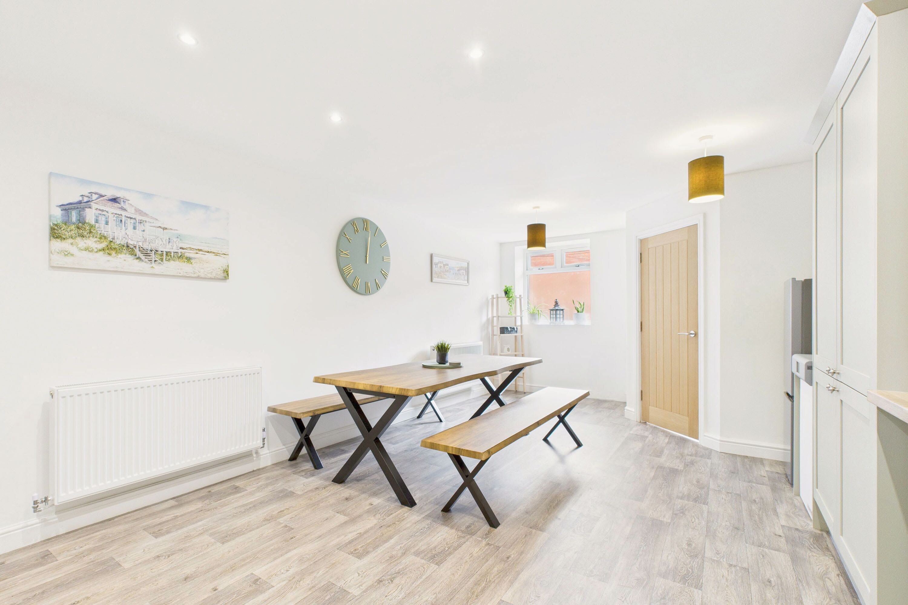 Une cuisine moderne avec des plans de travail en bois, un four encastré et une grande fenêtre.