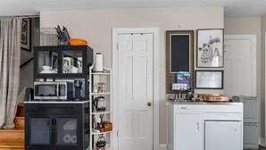 Eine kleine Küche mit einer Mikrowelle, einer Kaffeemaschine und einem Kühlschrank.