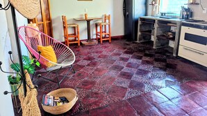 Eine kompakte Küche mit Kühlschrank, Herd und Essbereich mit Stühlen und Tisch.