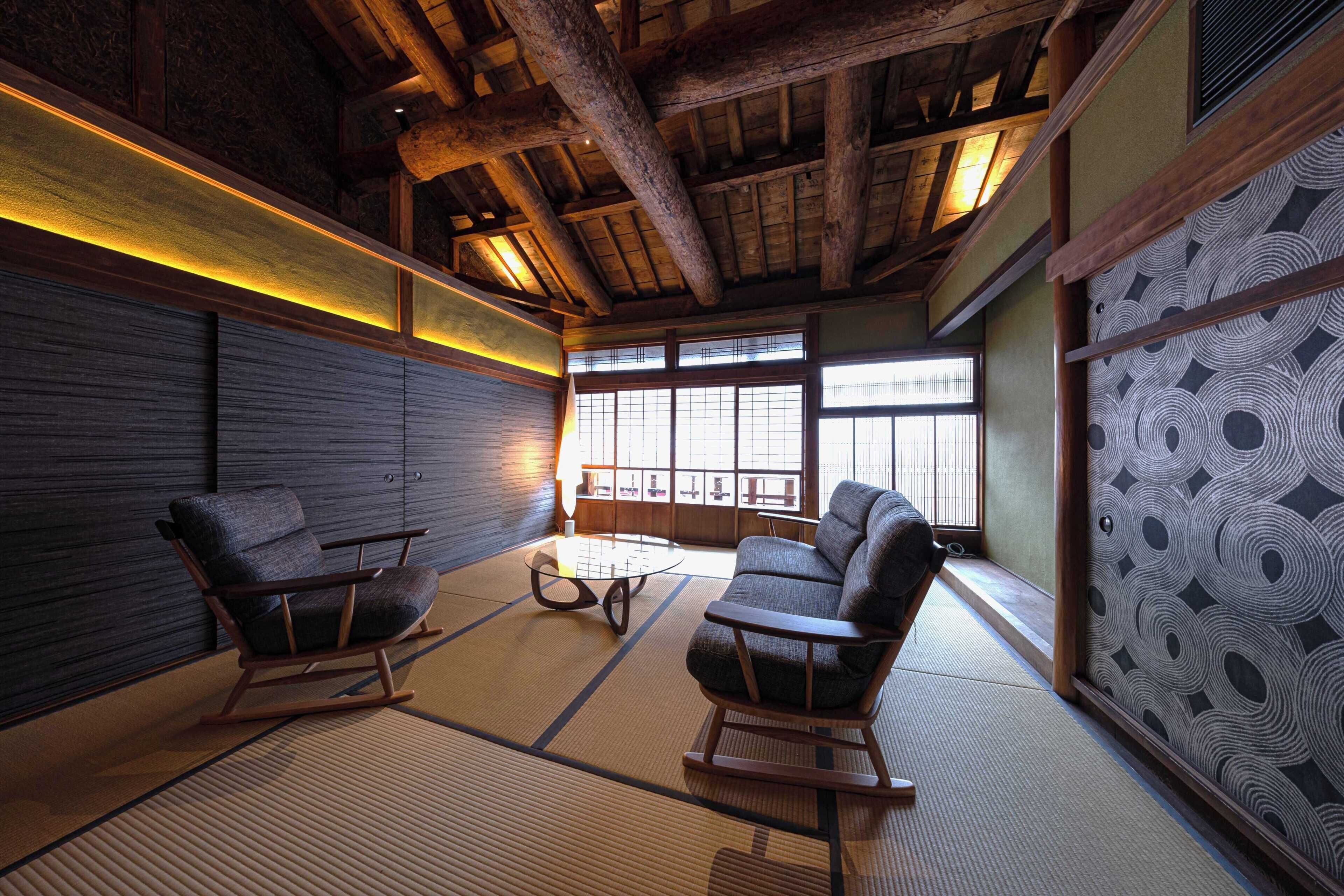 Una habitación japonesa tradicional con suelo de tatami, mobiliario de madera y vistas a través de amplios ventanales.