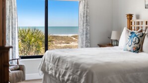 A bedroom with a large window, a bed, a nightstand, and a chair. - Gorgeous Oceanfront Retreat — Large Private Balcony, Private Beach Access & Pet-Friendly! ☀️ (Cocoa Beach)