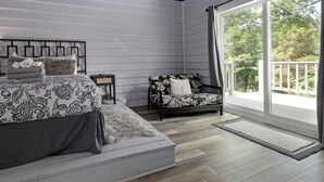 A bedroom with a bed, a chair, a small table, and a large window. - Dog-Friendly Lakeside Escape w/ Hammock & Fire Pit (Bahama)
