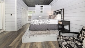 A bedroom with a bed, bedside table, and a built-in shelf above the bed. - Dog-Friendly Lakeside Escape w/ Hammock & Fire Pit (Bahama)