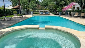 Una piscina cristalina con sillones de descanso y una zona de estar.