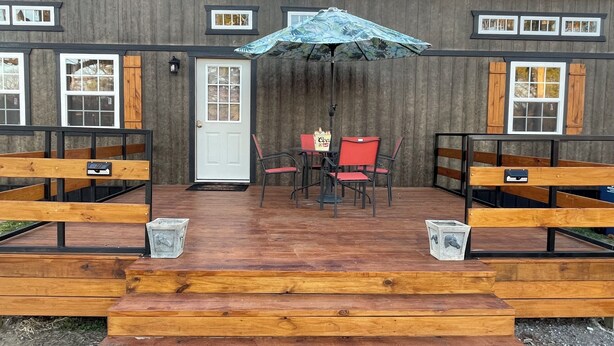 A wooden deck with a table and chairs, a door, and windows. - Quiet wake cabin in Crowder (Crowder)