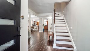 Een modern interieur met een houten trap, een keukenhoek en een eethoek.