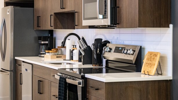 Eine moderne Küche mit Edelstahlgeräten, Holzschränken und einer Kaffeemaschine.