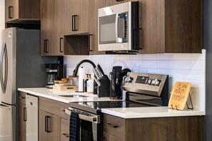 Una cucina moderna con elettrodomestici in acciaio inossidabile, mobili in legno e una macchina per il caffè.