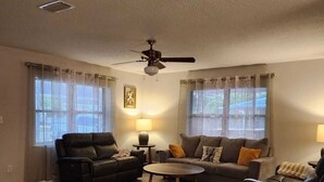 A living room with a ceiling fan, two sofas, a coffee table, and a lamp. - Space Coast Vacation Home — 5 Min to Kennedy Space Center & Beaches! (Titusville)