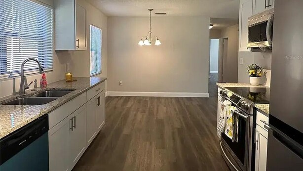 A modern kitchen with a central island, built-in appliances, and a pendant light fixture. - Space Coast Vacation Home — 5 Min to Kennedy Space Center & Beaches! (Titusville)