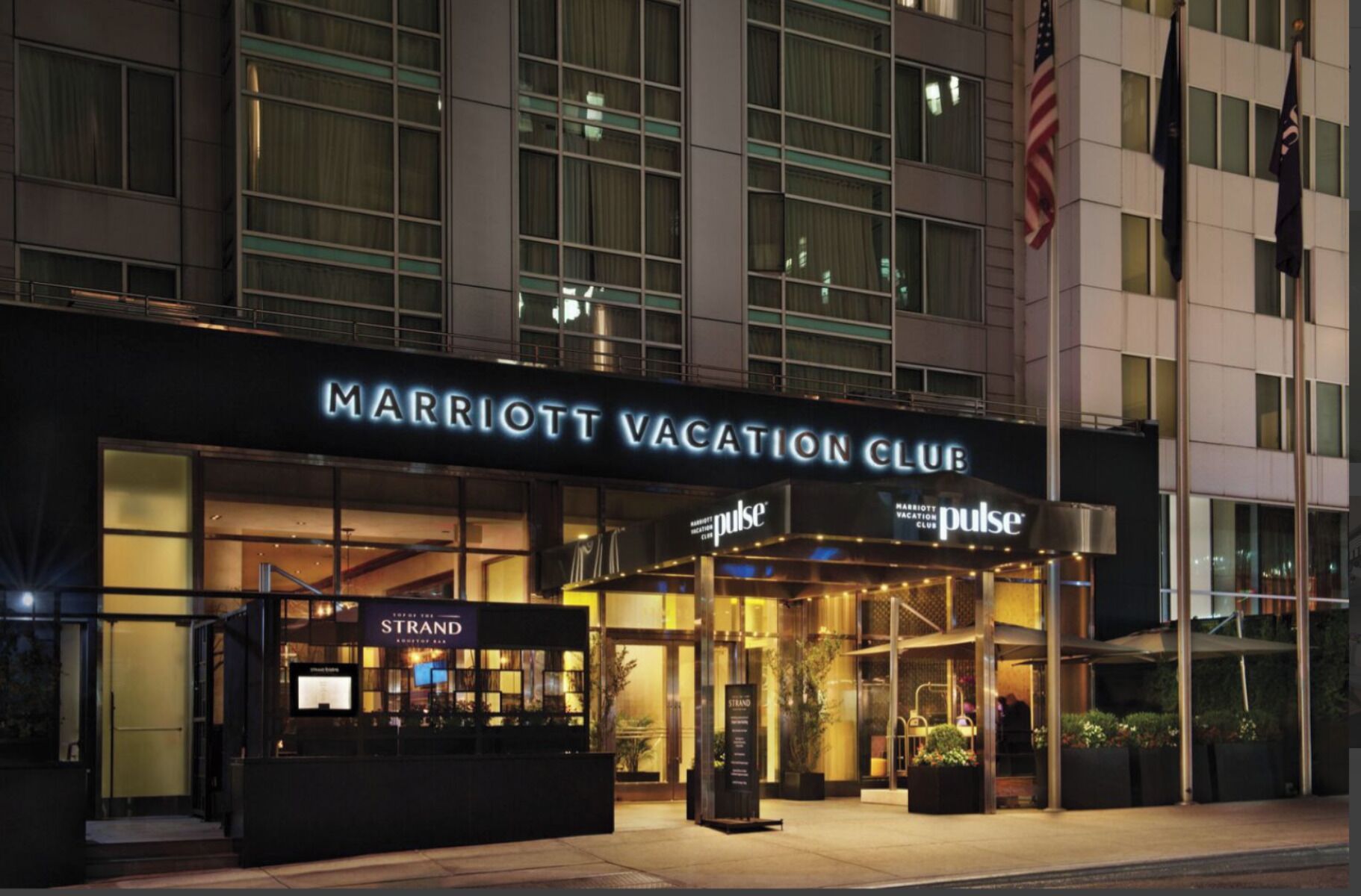 The exterior of the Marriott Vacation Club with a prominent entrance and signage for the Strand restaurant.