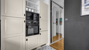 Una cocina moderna con armarios blancos, un microondas y un horno.
