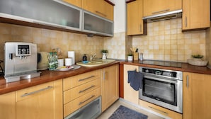 Une cuisine moderne avec des meubles en bois, des appareils électroménagers en acier inoxydable et un dosseret carrelé.