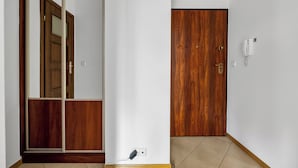 Un couloir avec une porte en bois, un téléphone et une prise de courant.