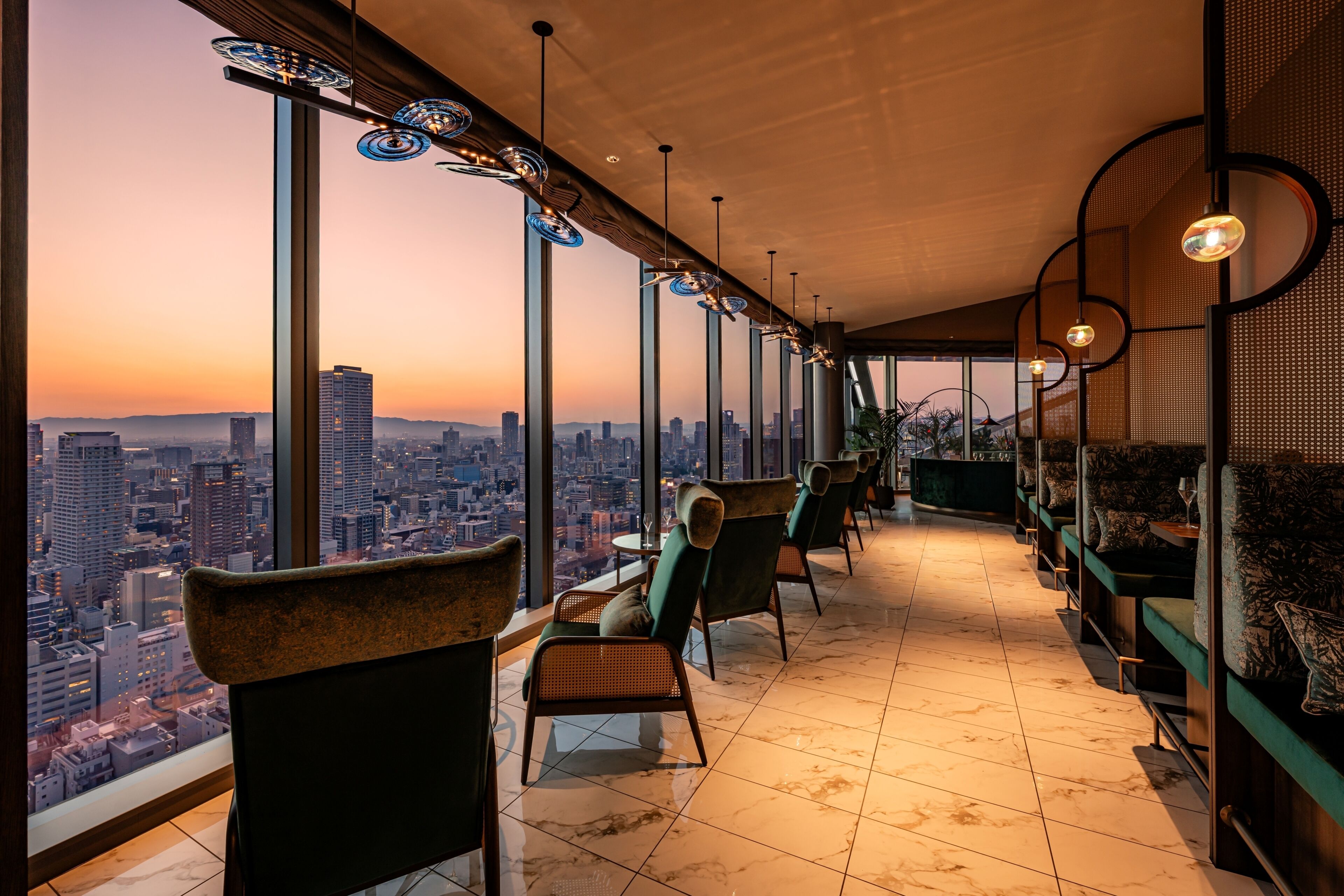 A high-rise interior with a city view, modern furniture, and a bar area.