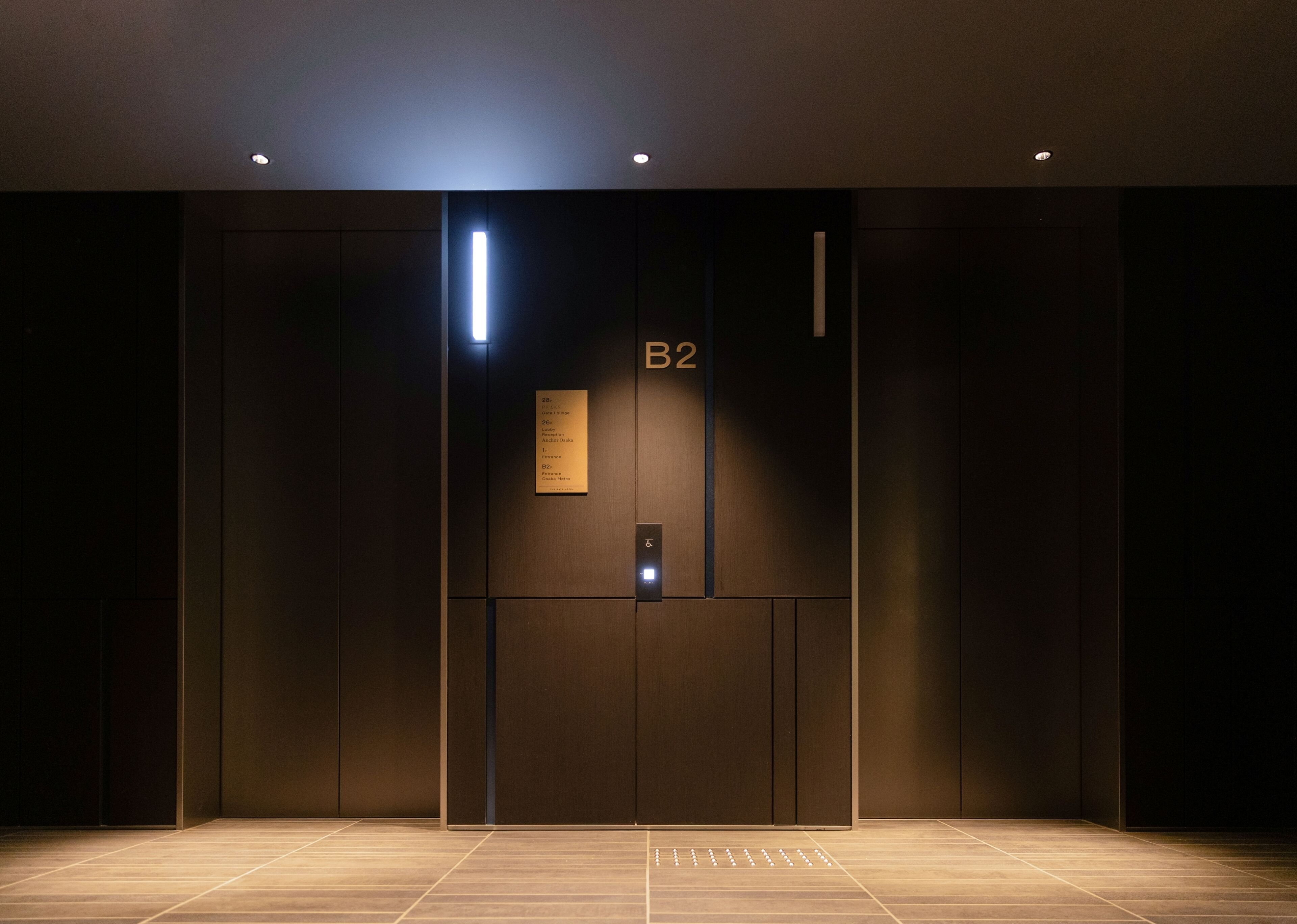 An elevator interior with a sign indicating 'B2' and a list of room names.