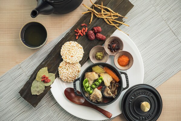 A traditional meal setup with a pot, a plate with food, a cup, and a teapot on a woven mat. - THE GATE HOTEL OSAKA by HULIC (Osaka)