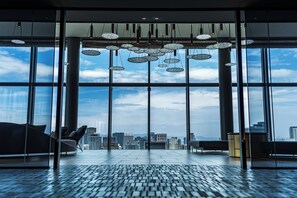 A spacious interior with large windows, a modern ceiling design, and a view of the cityscape. - THE GATE HOTEL OSAKA by HULIC (Osaka)