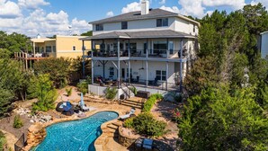 A two-story house with a swimming pool, outdoor seating, and a deck. - Peckham Point 5 Bd Lake View Retreat w Private Pool (Point Venture)