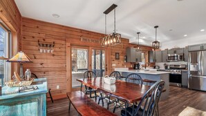 A modern kitchen with wooden walls, stainless steel appliances, and a central island. - Sundance Summit: A 4 BR retreat in a Ski-in/Ski-out Community near Wisp (McHenry)