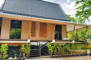 Een modern huis met een pannendak, houten gevel en een overdekte veranda met treden naar de ingang.