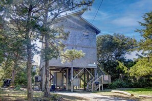 A two-story building with a wooden deck and a covered area.