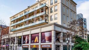 Ein mehrstöckiges Hotel mit Balkonen, einem McDonald's und einem Starbucks.