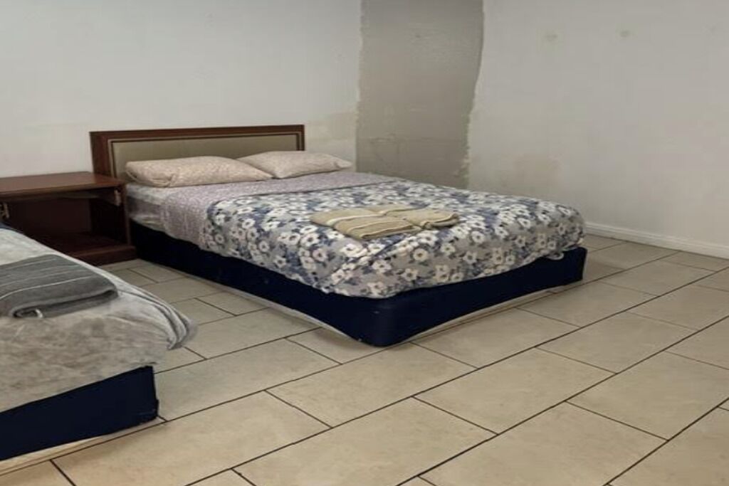 Un dormitorio con una cama, una mesita de noche y un aparador.