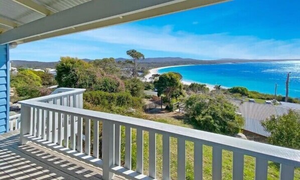 Een balkon met uitzicht op een strand en de oceaan.