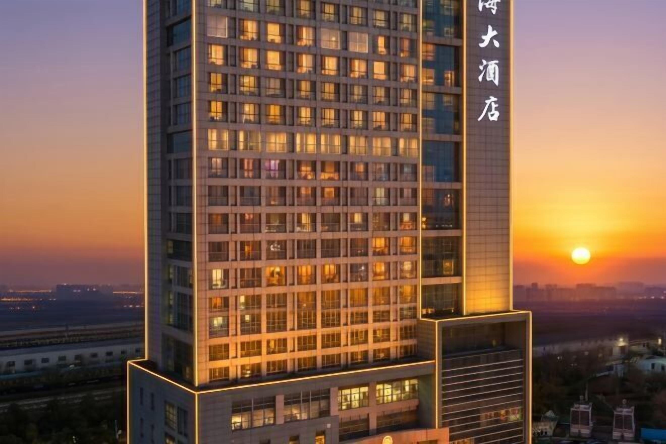 A high-rise hotel with multiple floors, large windows, and a prominent entrance.