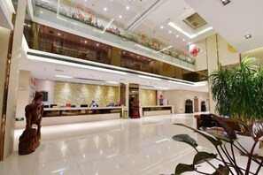 A spacious lobby with a reception desk, a staircase, and a large plant. - Jinhai Hotel (Yantai Railway Station Wuyue Plaza) (Yantai)