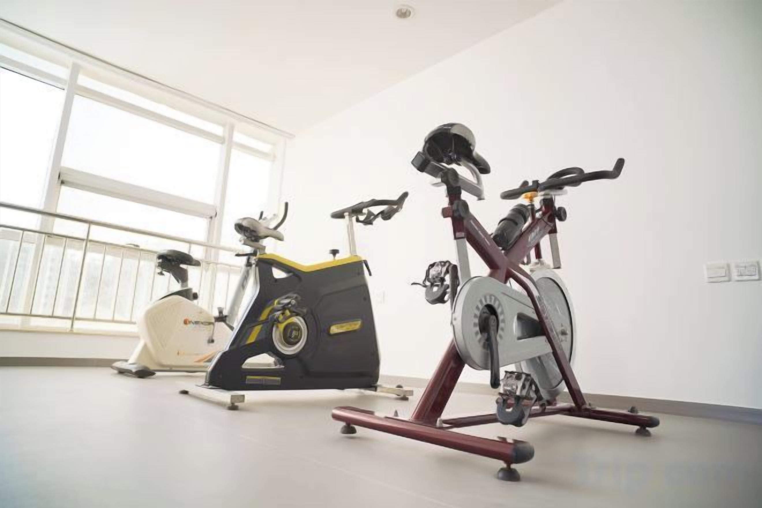 Una habitación con bicicletas estáticas y un ventanal amplio.