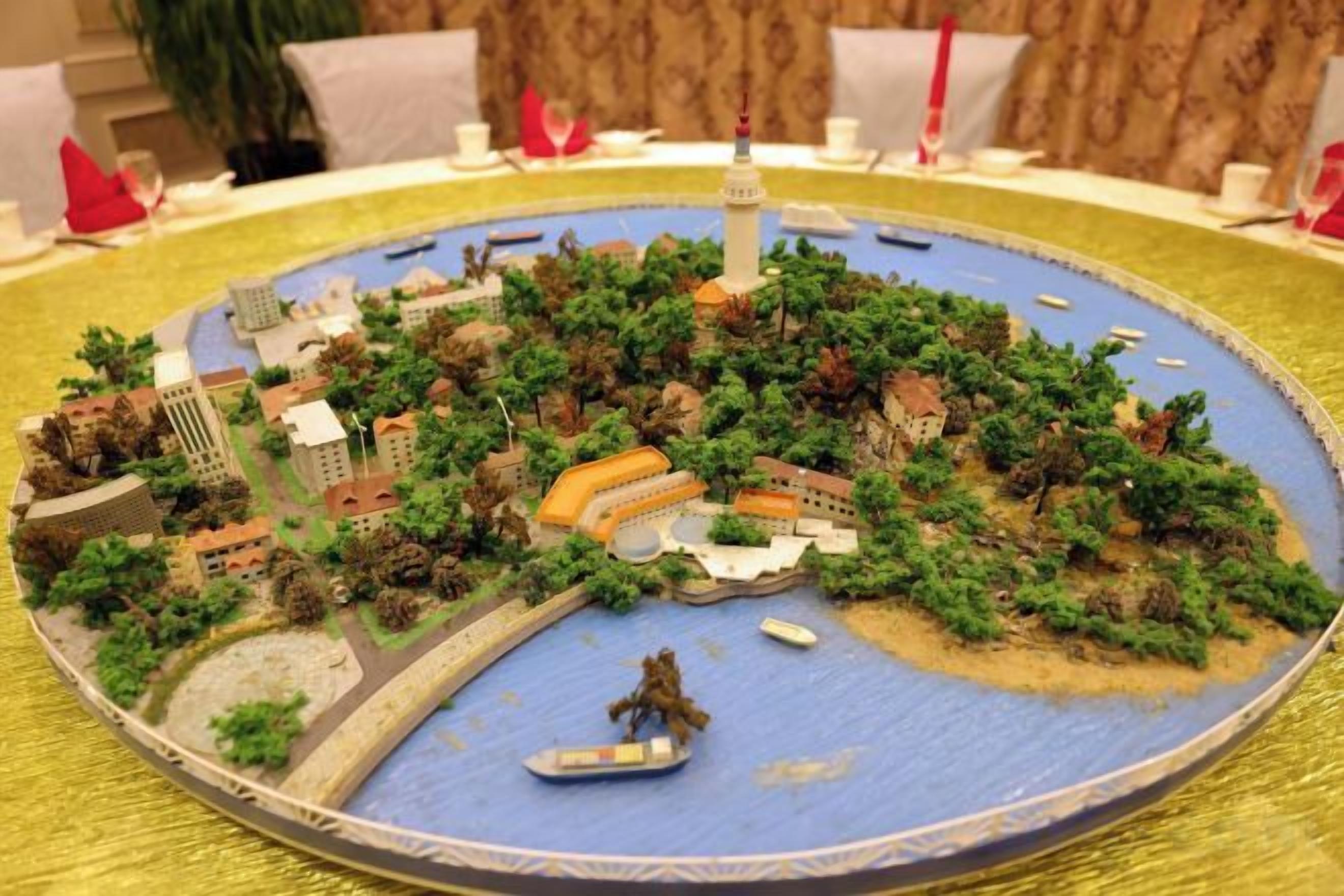 A detailed model of a cityscape with a prominent tower, bridges, and a body of water.