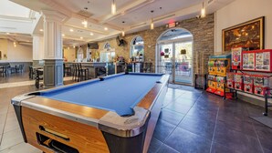 A pool table in a well-lit indoor space with a bar area and arcade machines. - Near Disney Regal Palms Renovated Resort-New Pool-Lazy River-Arcade-Kid Friendly (Davenport)