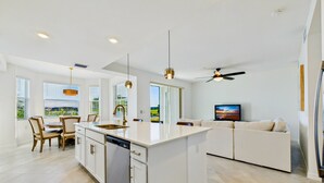 A modern kitchen with a central island, white cabinetry, and a dishwasher. - Enjoy a luxury 2BR/2BA Condo in beautiful Ave Maria Golf and Country Club (Ave Maria)