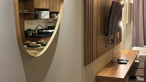A modern kitchen with a large mirror, wooden cabinets, and a built-in microwave. - Apartment / Beachfront / Pool / Intermares (Cabedelo)