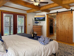 A bedroom with a bed, a dresser, a painting, and a sliding door. - Summit Trail Lodge – Mountain Views, Sauna, Game Room, Hot Tub (Blue Ridge)