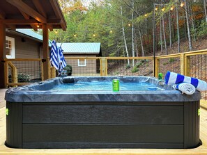 A hot tub with a wooden deck, surrounded by a wooden fence and trees. - Summit Trail Lodge – Mountain Views, Sauna, Game Room, Hot Tub (Blue Ridge)