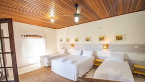 Une chambre d’hôtel avec deux lits, un plafond en bois et des œuvres d’art accrochées aux murs.