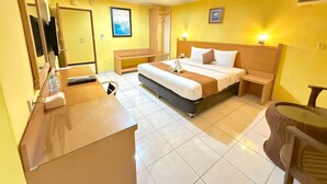 Een hotelkamer met een bed, nachtkastjes, een bureau en een spiegel.