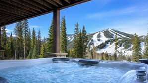 A hot tub with a mountain view, wooden pergola, and stone structure. - Lakota Dreamcatcher North | Sauna | Slope Views | Private Hot Tub (Winter Park)