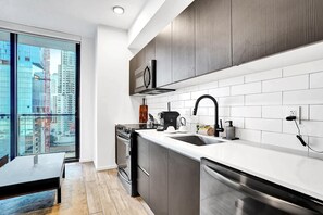 A modern kitchen with a large window, stainless steel appliances, and a view of the cityscape. - Bay View Studio | Rooftop Pool, Downtown Miami (Miami)