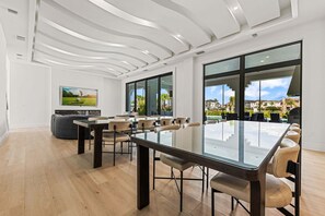 Una sala de conferencias moderna con una mesa de cristal, sillas de cuero y grandes ventanales con vistas al exterior.
