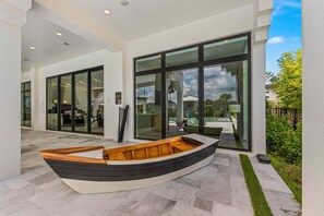 A modern building with large glass doors, a boat-shaped bench, and a well-maintained outdoor area. - The Nautilus at Reunion-TT488 (Kissimmee)