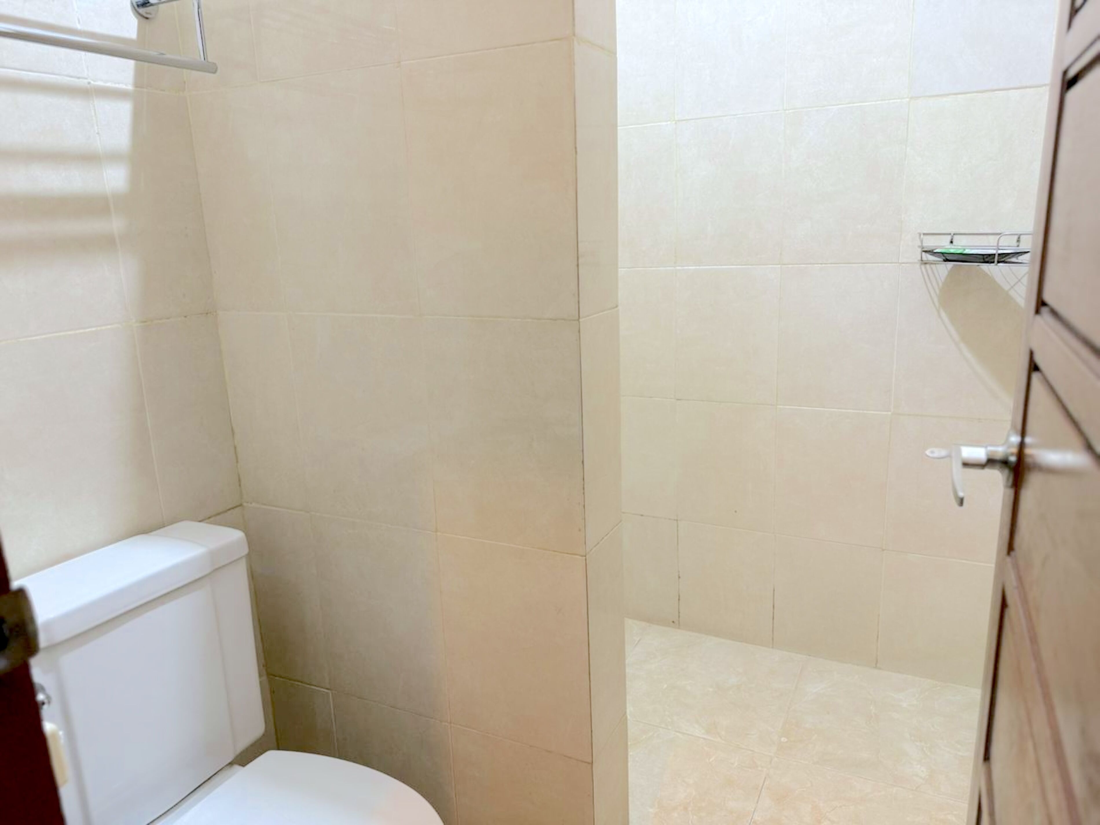 Un baño con inodoro, zona de ducha y lavamanos.