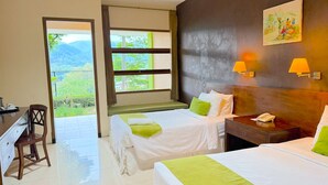 A hotel room with two beds, a desk, and a chair. There is a window with a view of greenery and a painting on the wall. - De View Hotel Batu (Batu)
