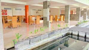 A spacious indoor area with multiple seating arrangements, a central water feature, and a modern architectural design. - De View Hotel Batu (Batu)