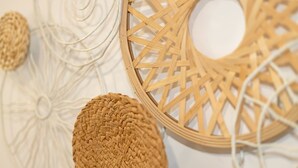Un cesto intrecciato e un elemento decorativo a parete in primo piano.