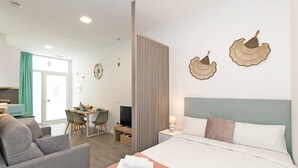 Una camera d'albergo con un letto, una scrivania, una sedia e una televisione.